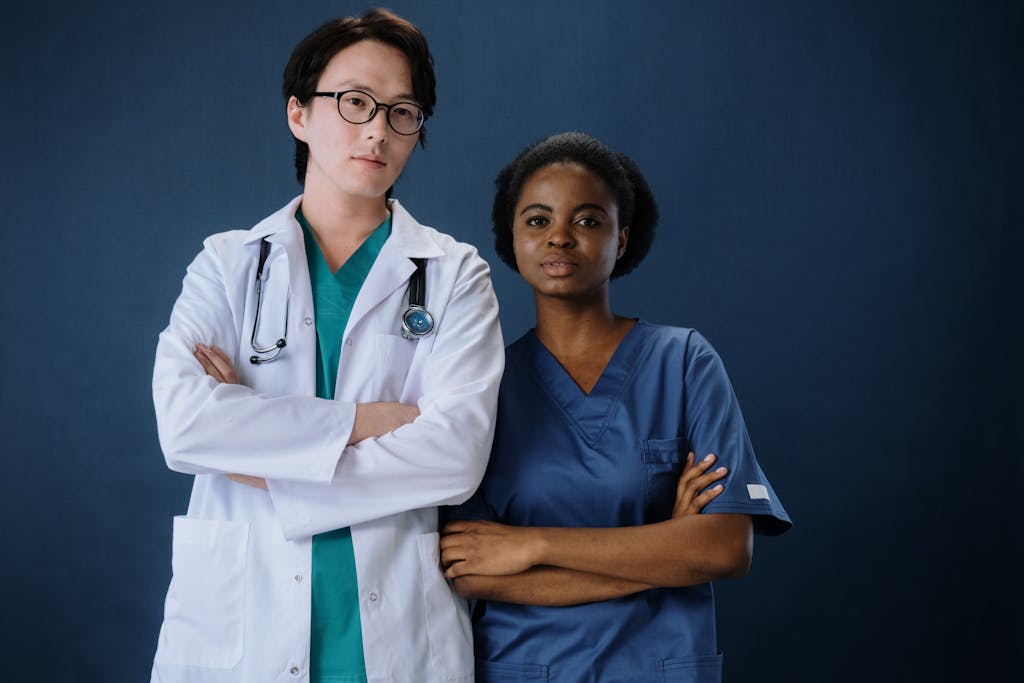 A confident doctor and nurse posing in a studio setting.